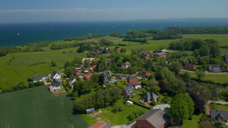 Aerial-drone-circling-around-suburbs-houses-residential-area-in-Brodten,-Germany,-background-Baltic-sea,-day